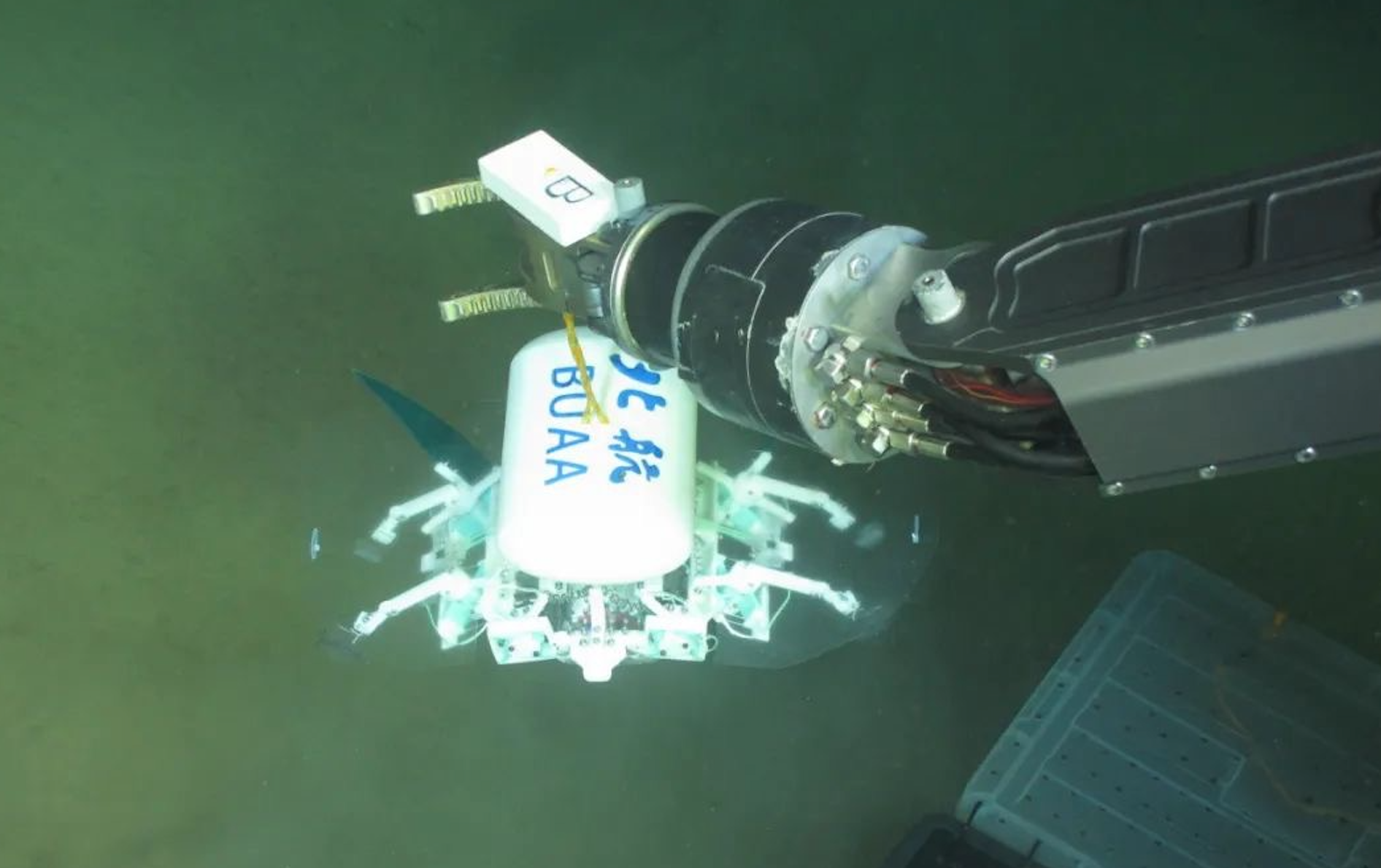 科研人員利用機械臂將北航深海小型機器人投于馬里亞納海溝。校方供圖