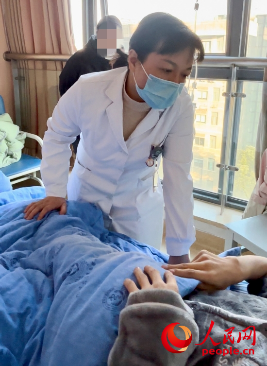 鄧茜查房時詢問患者情況。人民網(wǎng)記者 金慧慧攝