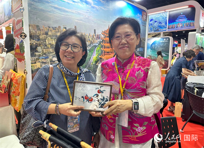 中國“大冶刺繡”傳承人劉小紅（右）參加泰國國際旅游展，向觀眾介紹中國非遺刺繡針法。人民網(wǎng)記者 簡承淵攝