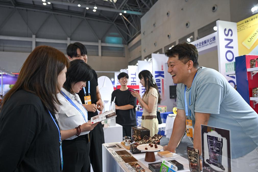 5月22日，韓國(guó)展商（右一）在西洽會(huì)現(xiàn)場(chǎng)向參觀者介紹產(chǎn)品。新華社記者 陳誠(chéng) 攝